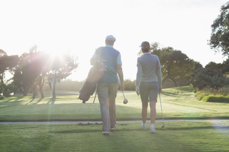 Golfing couple walking and chatting on a sunny day at the golf course